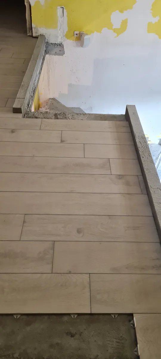 Pose carrelage damier sous l'escalier béton à Sin-le-Noble